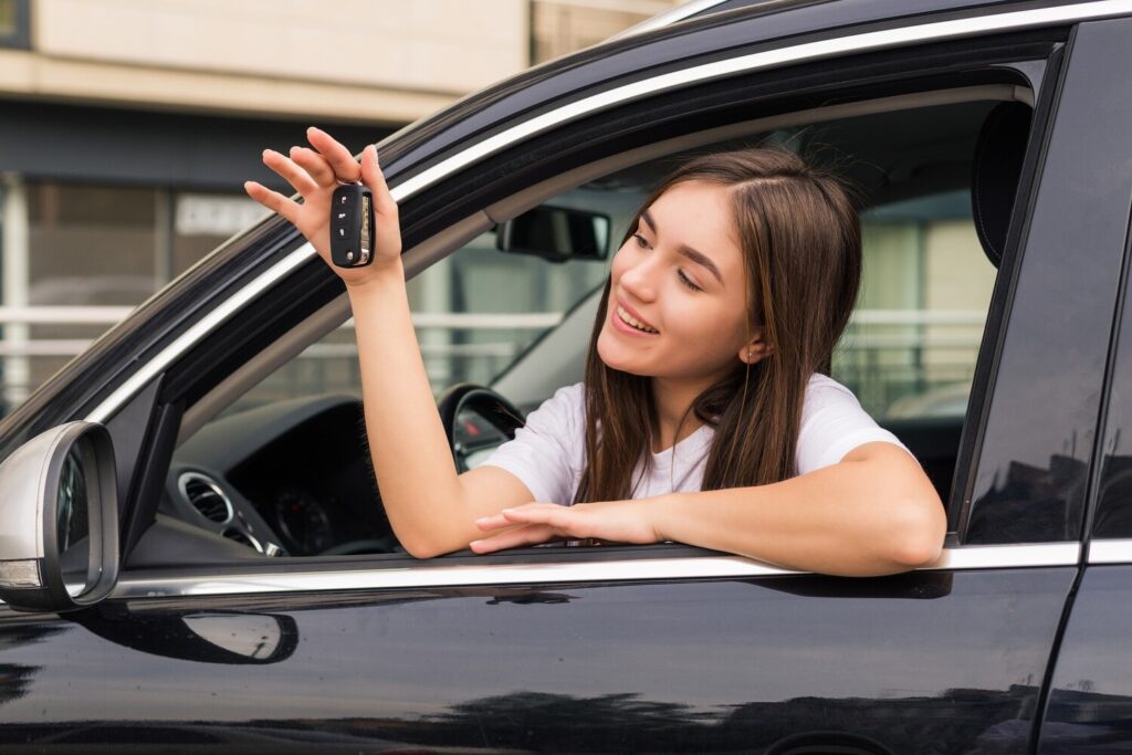 Happy young smiling woman with new car key 231208 11939